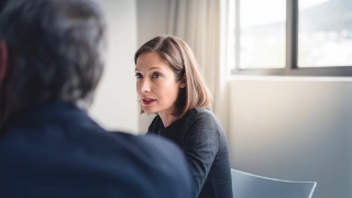 Mitarbeiterin diskutiert mit einem Mitarbeiter in einem Sitzungszimmer